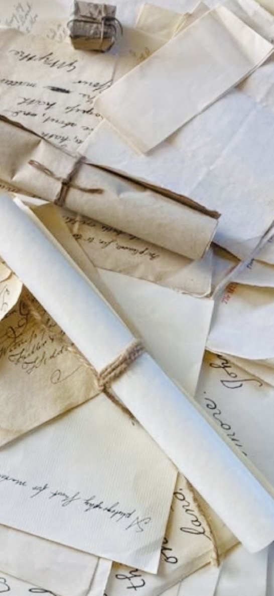 Handwritten letters and paper scrolls tied with twine